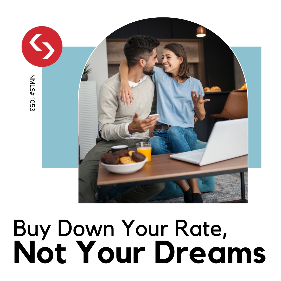 Happy couple sitting at a table with a laptop, discussing how to buy down their mortgage rate to make homeownership more affordable